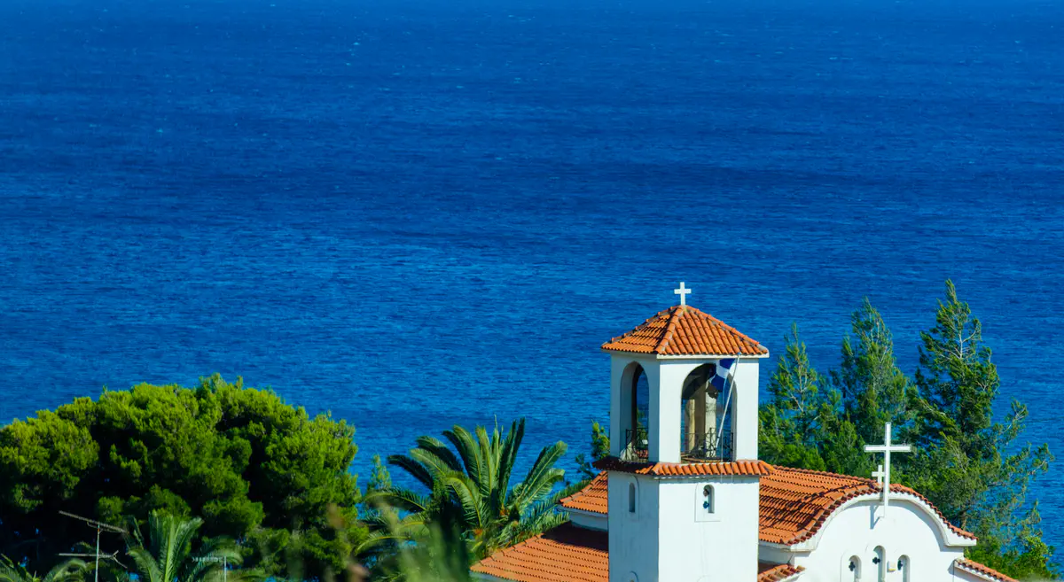 A photograph of a church with the sea in the background